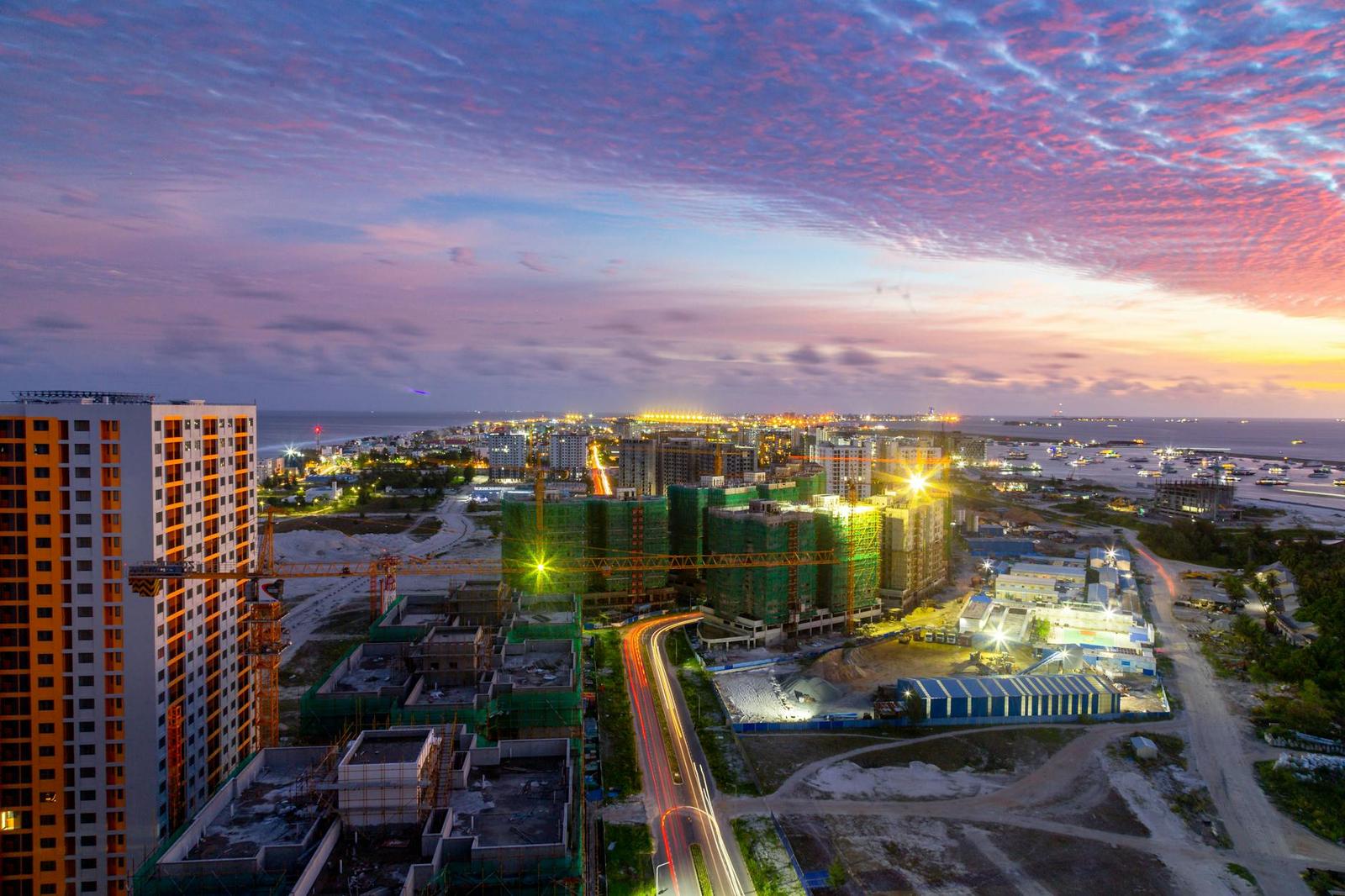 Aerial view of a city skyline under construction at dusk