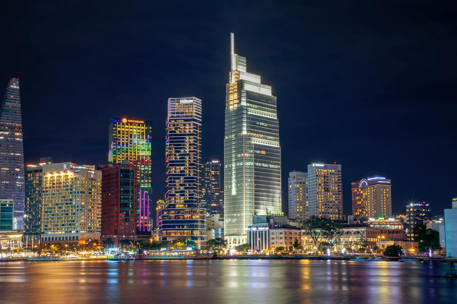 City skyline lit up along a river at night