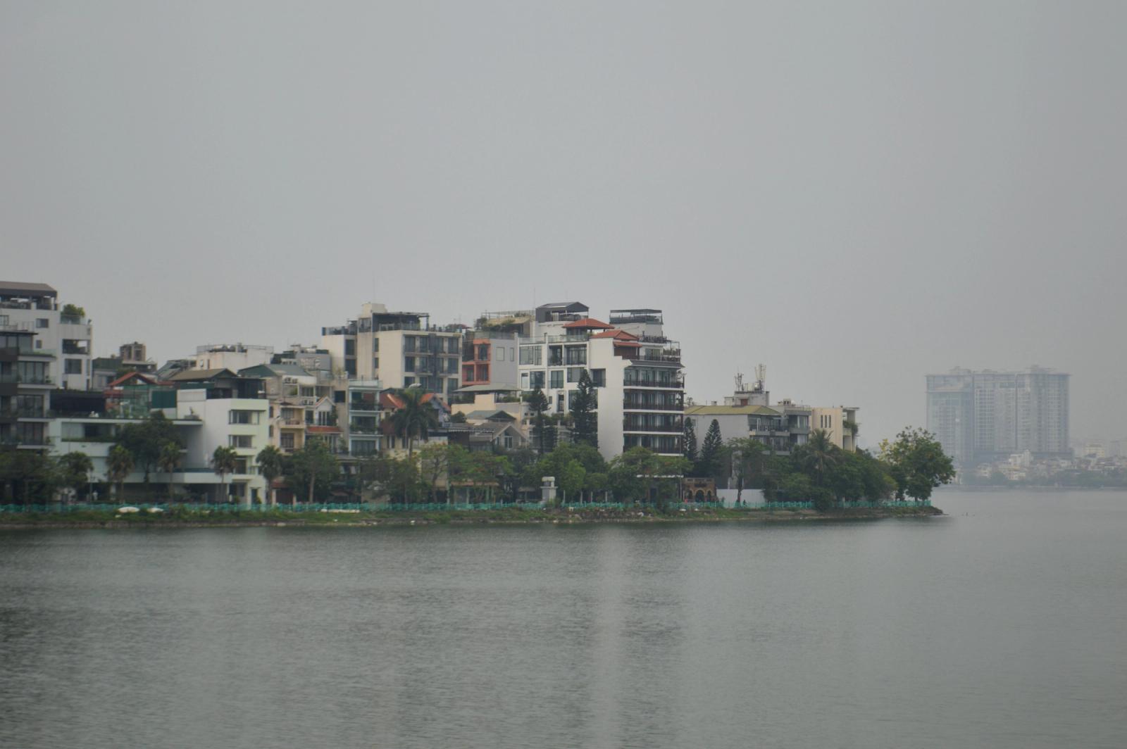 Discover the serene riverside buildings and skyline in Hanoi, captured on a cloudy day