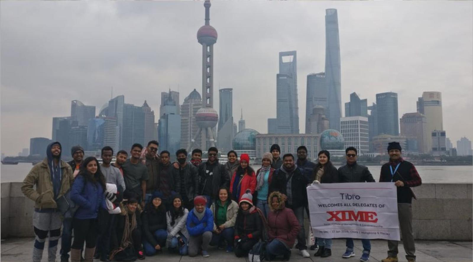 People standing together while presenting a large promotional banner.