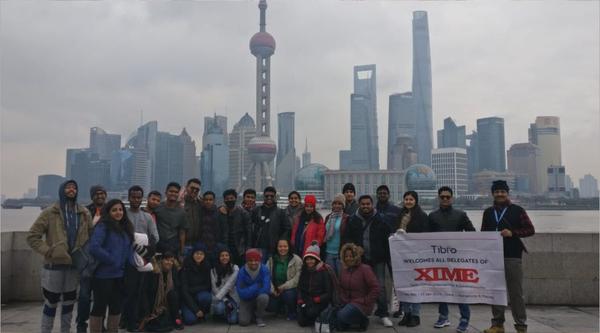 People standing together while presenting a large promotional banner.