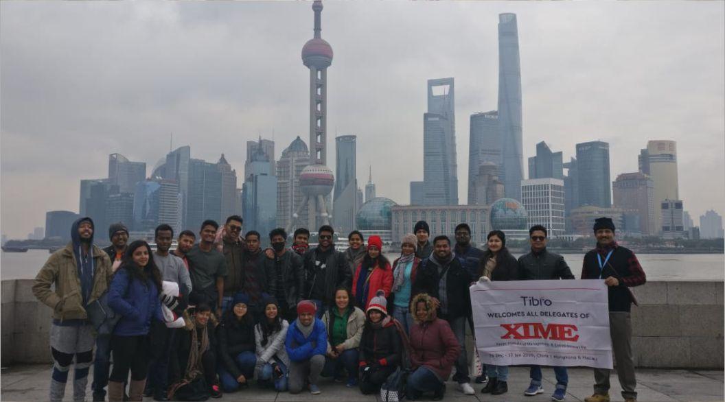 People standing together while presenting a large promotional banner.
