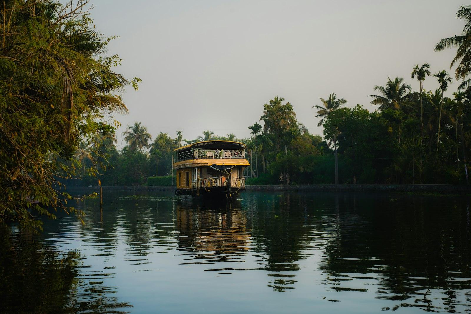 A houseboat on the Alleppey backwaters at dusk, palms along the bank