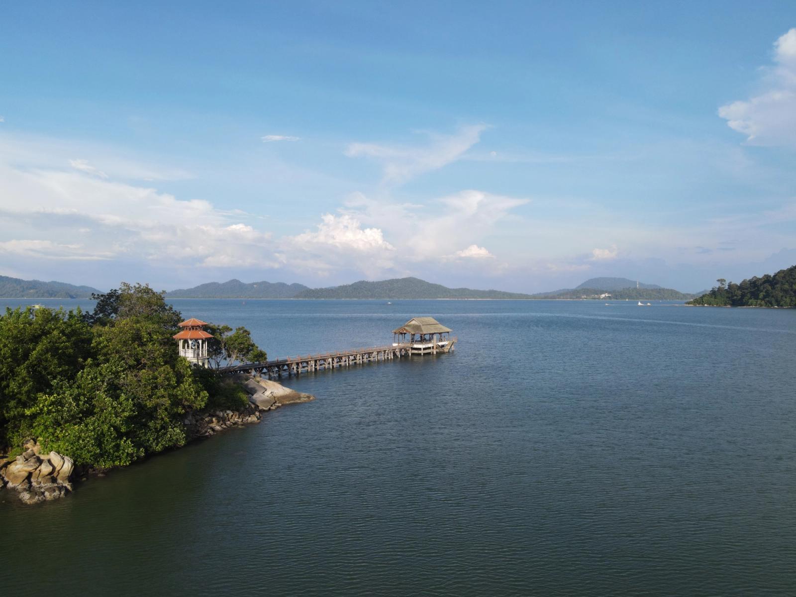 A serene view of a wooden pier extending into the sea at Pangkor Island, Malaysia