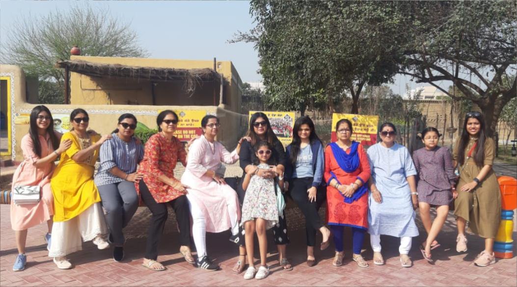 A group of women and a child posing outdoors on a sunny day.