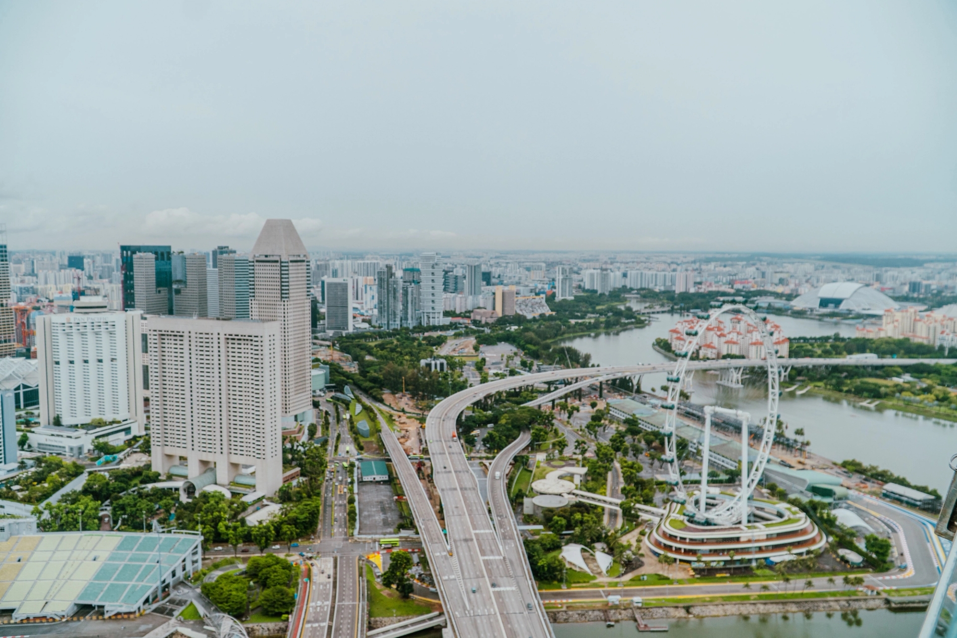 Stunning aerial view of Singapore cityscape featuring Marina Bay Sands and Singapore Flyer on a cloudy day