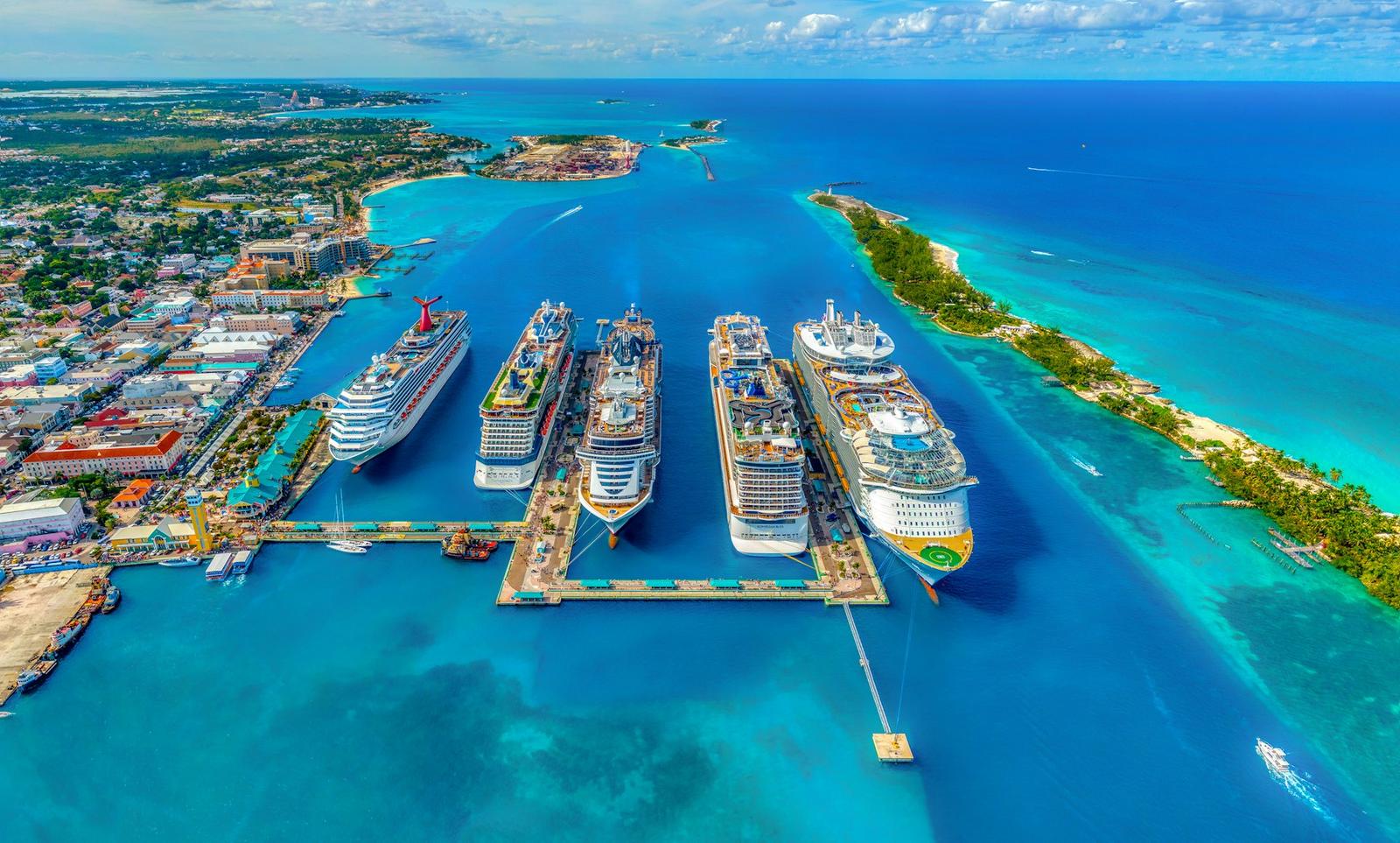 Large white cruise ship sailing on open blue water at sunset
