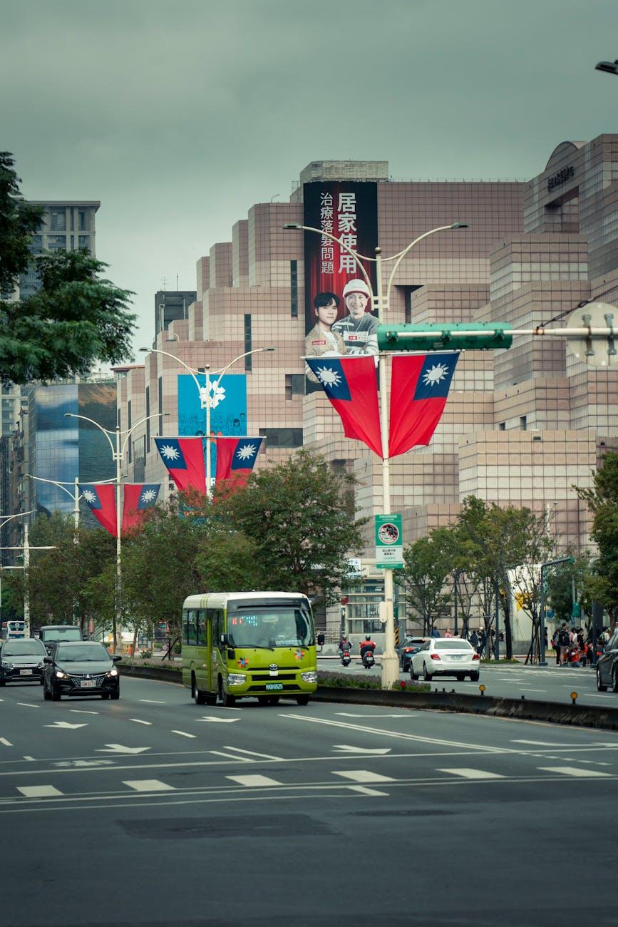 City street hung with large flags beside a billboard-covered building