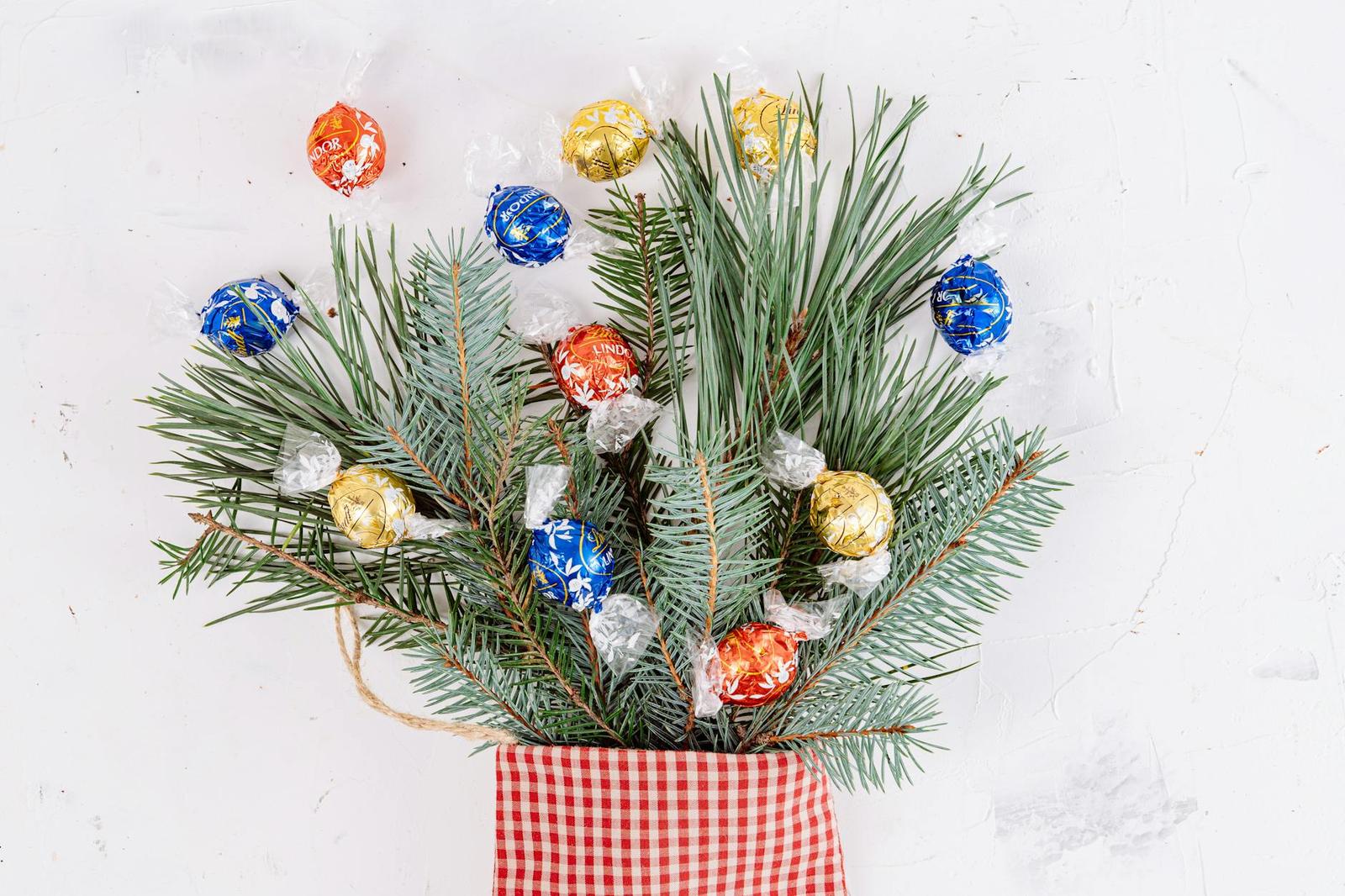 Foil-wrapped chocolate balls arranged on pine sprigs in a gift bag