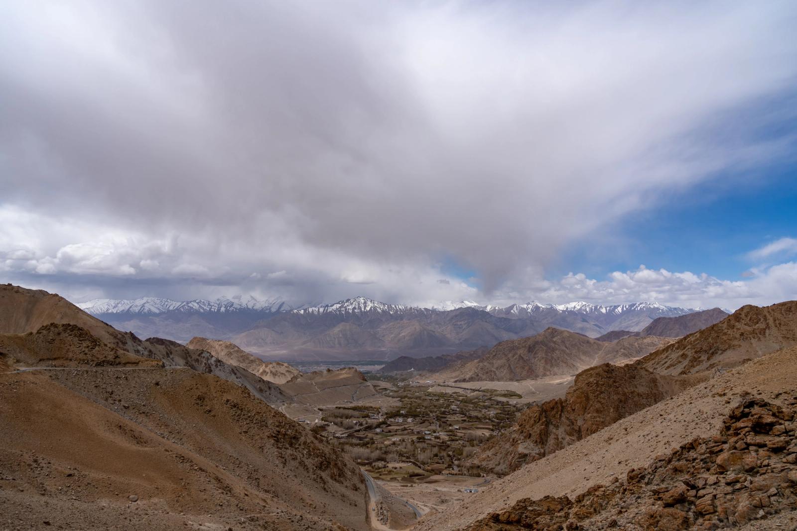 Dramatic landscape of Leh with snowcapped mountains under a vast cloudy sky
