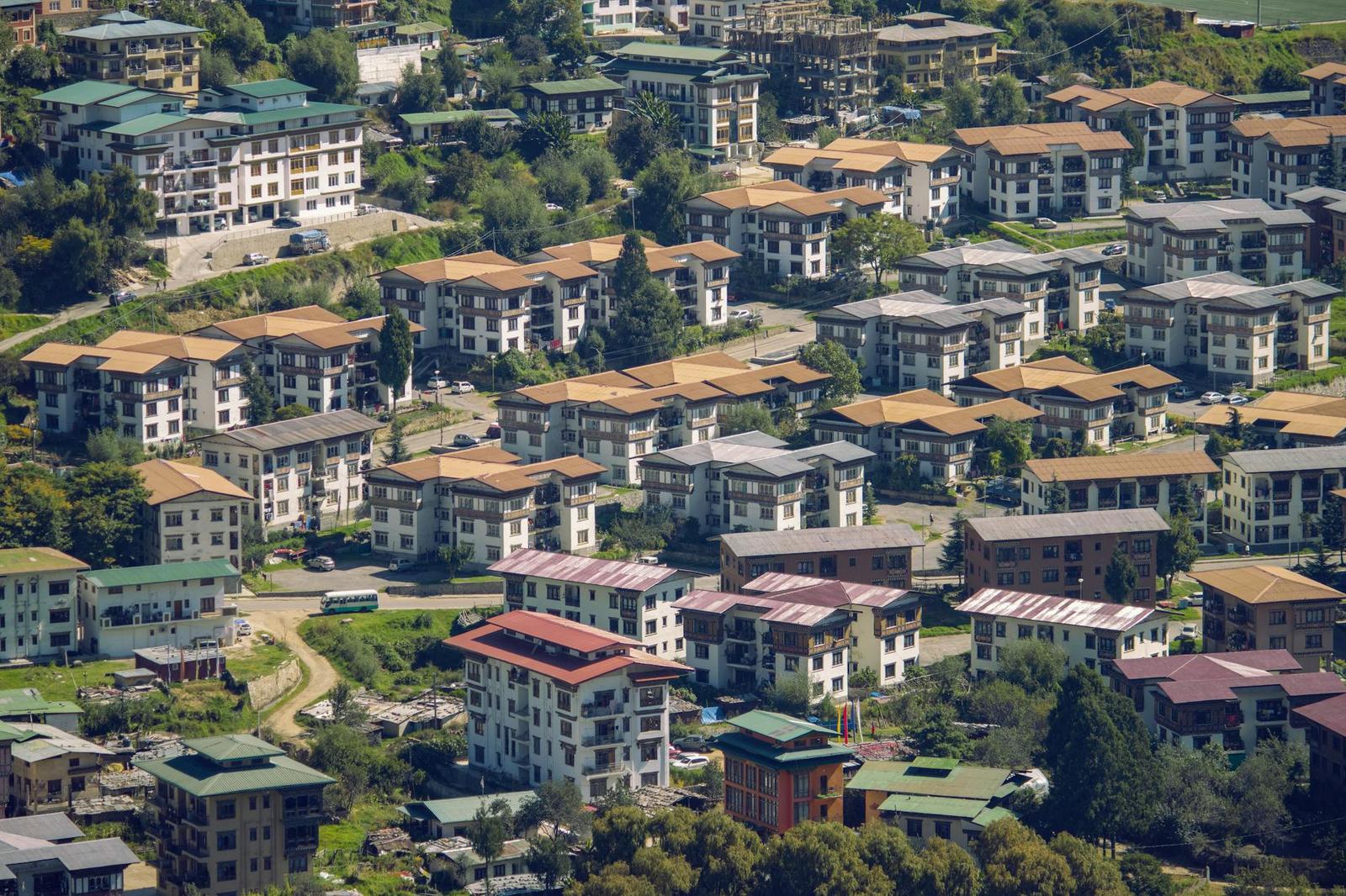 Aerial view of dense apartment buildings with orange roofs on a hillside