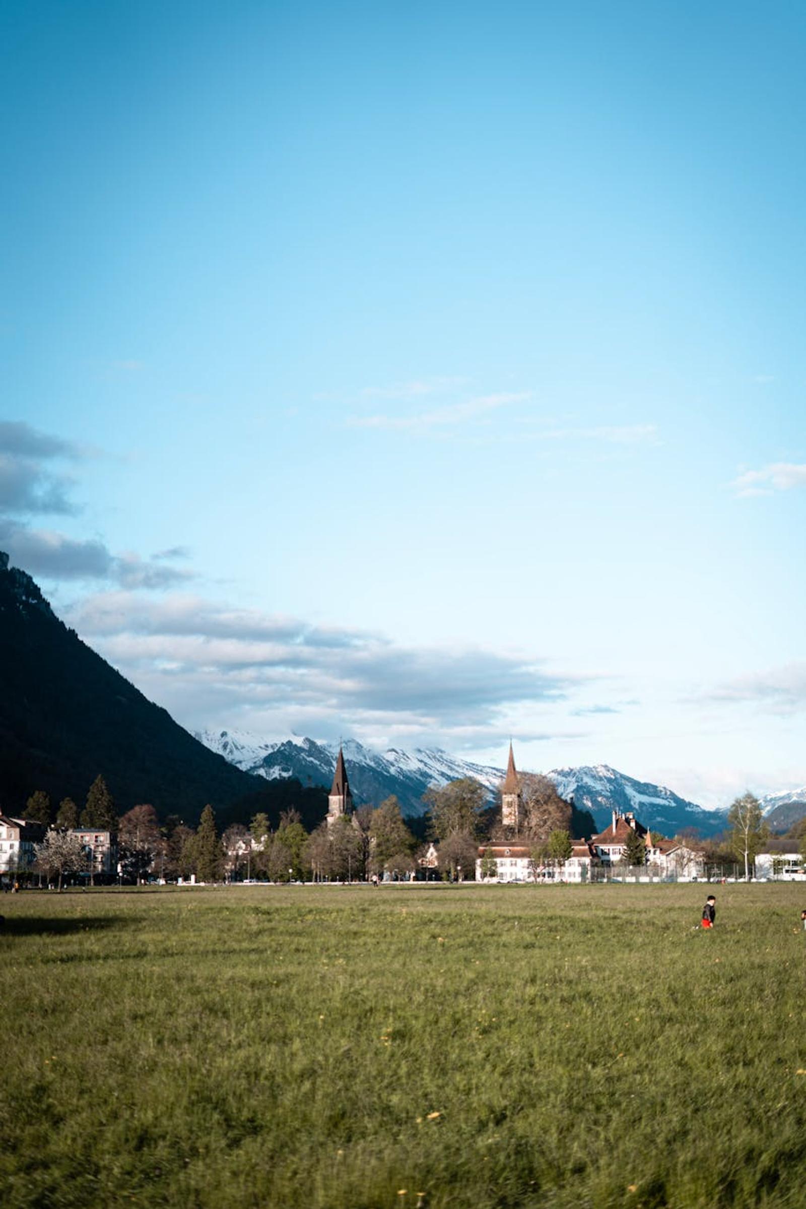 Alpine town with church spires set against snow-capped mountains