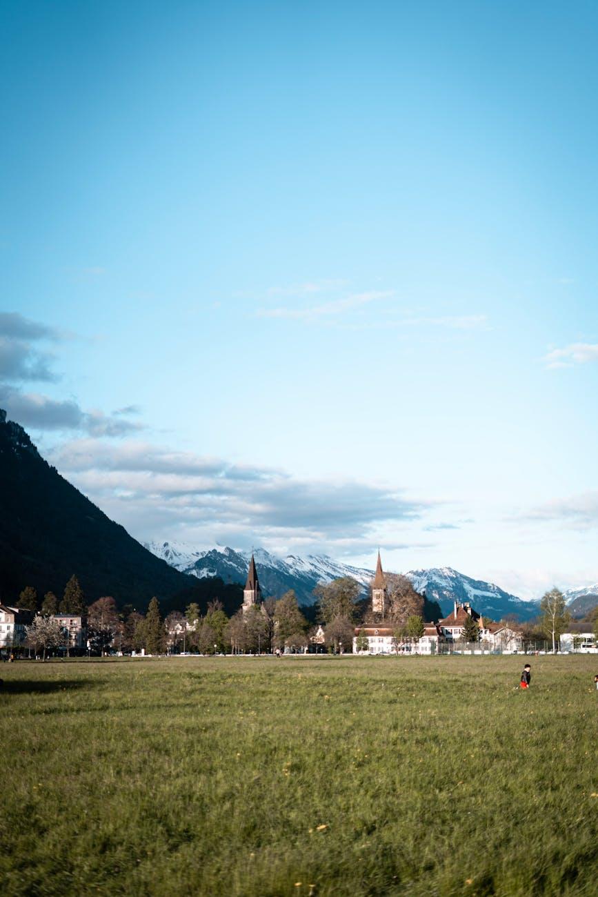 Alpine town with church spires set against snow-capped mountains