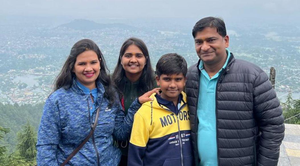 Family posing at a scenic viewpoint with a misty landscape backdrop.