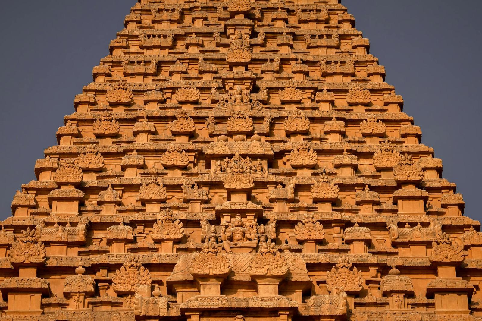 Close-up of a stepped stone temple tower covered in repeating carved niches