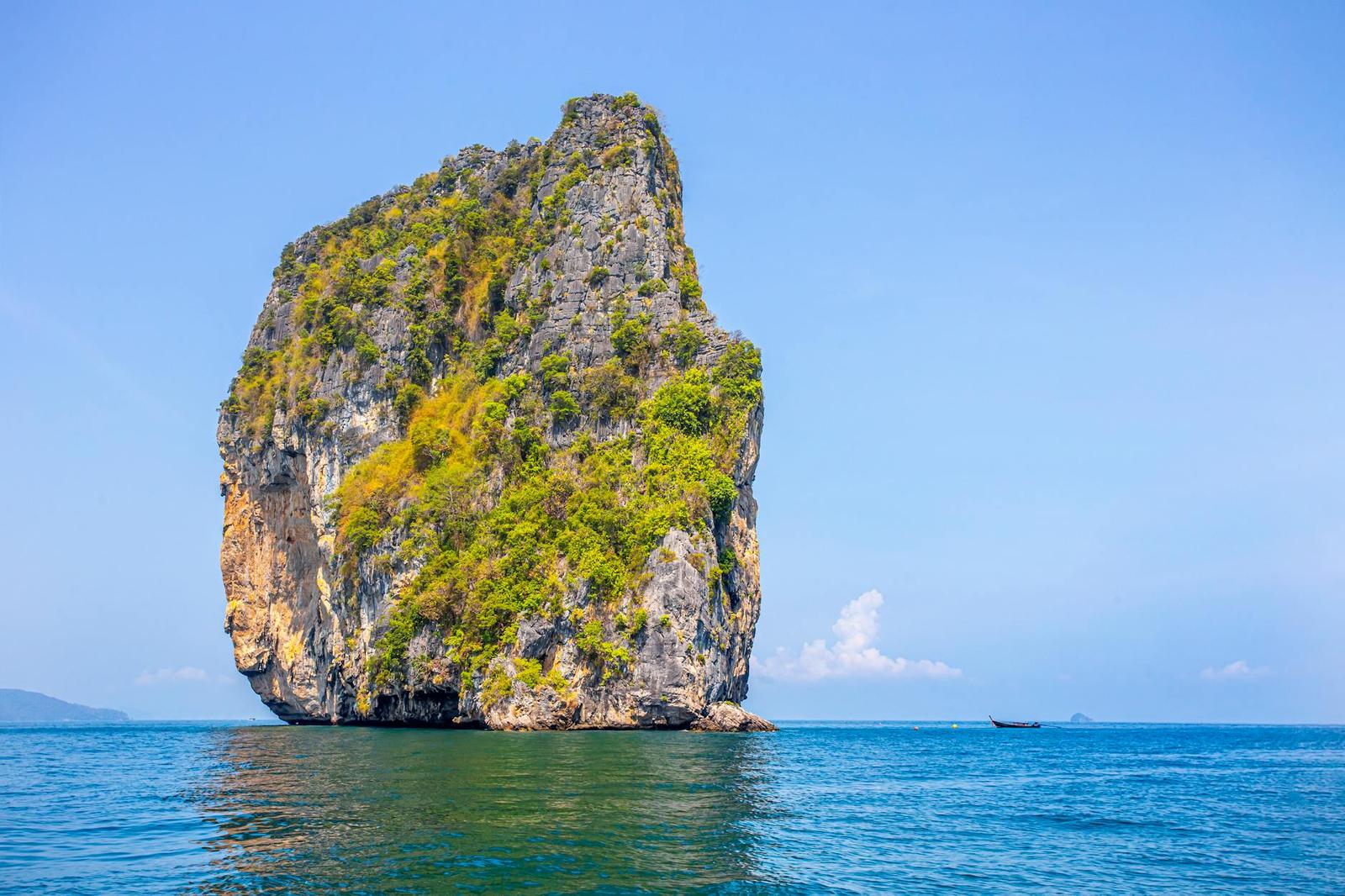 Majestic limestone island rising from the Andaman Sea under a clear blue sky in Krabi, Thailand