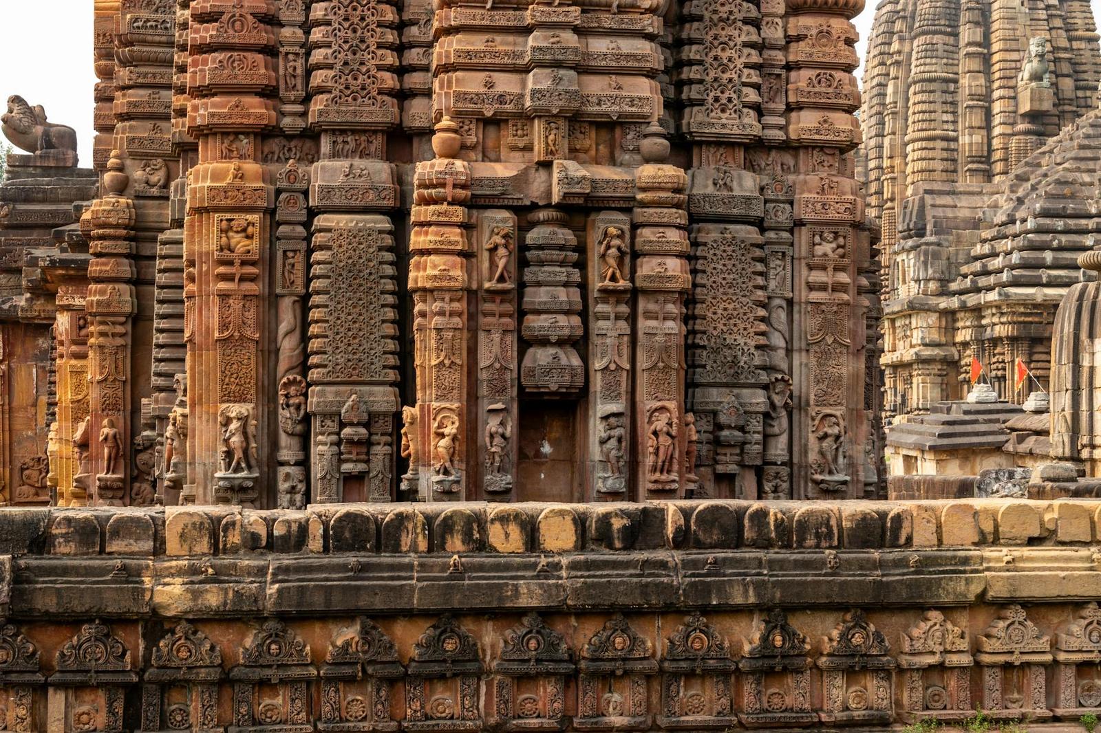 Intricately carved stone temple spires rising behind a low boundary wall