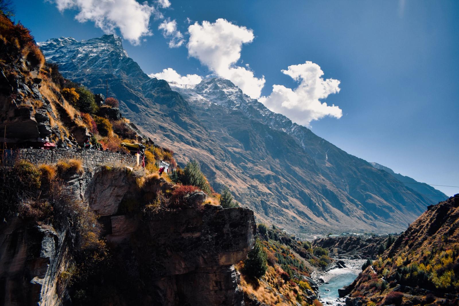 Scenic view of majestic mountains and stream in Kedarnath, India, under a clear blue sky