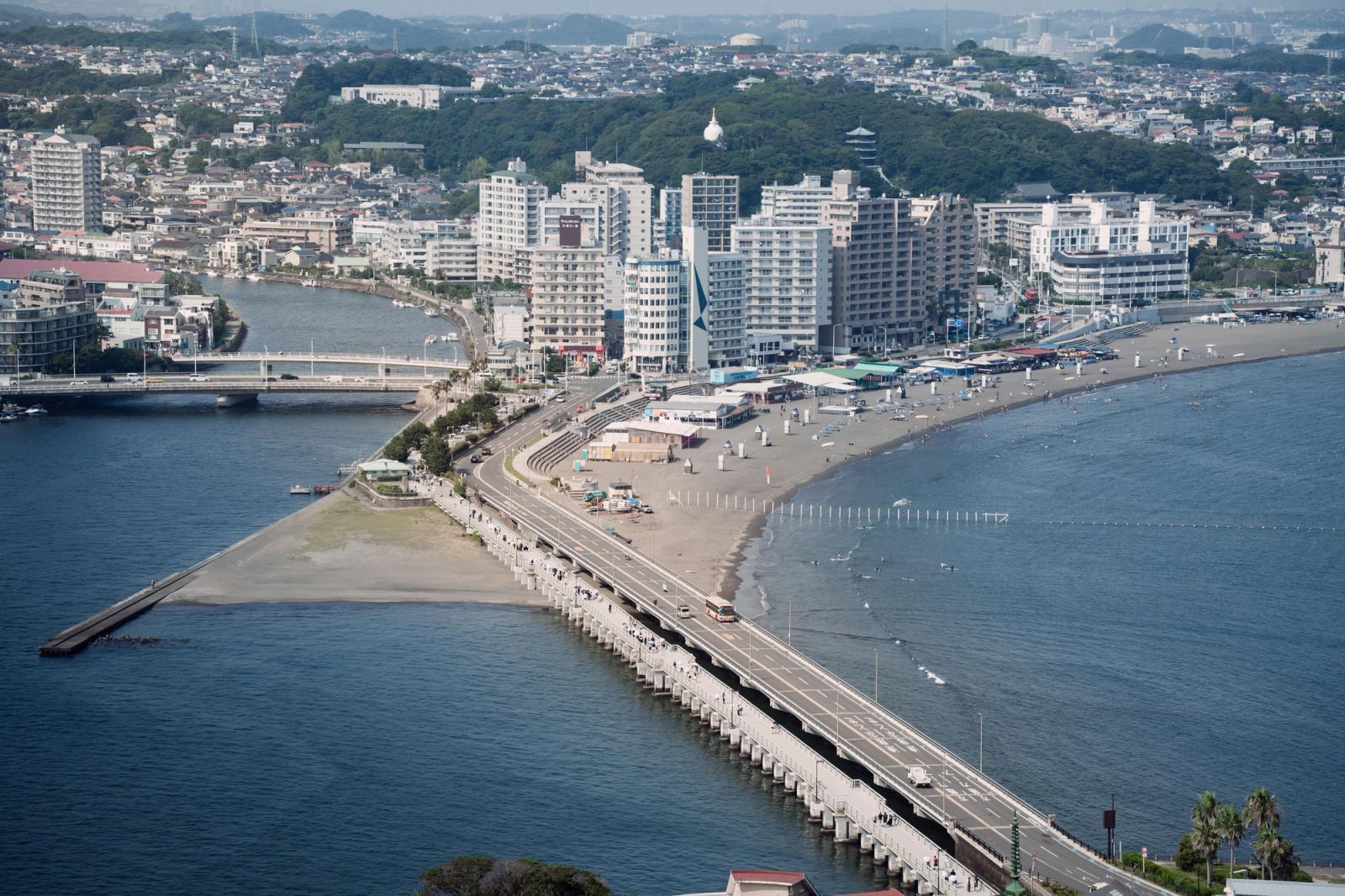 Stunning aerial view of Enoshima bridge, beach, and cityscape along the Tokyo coastline