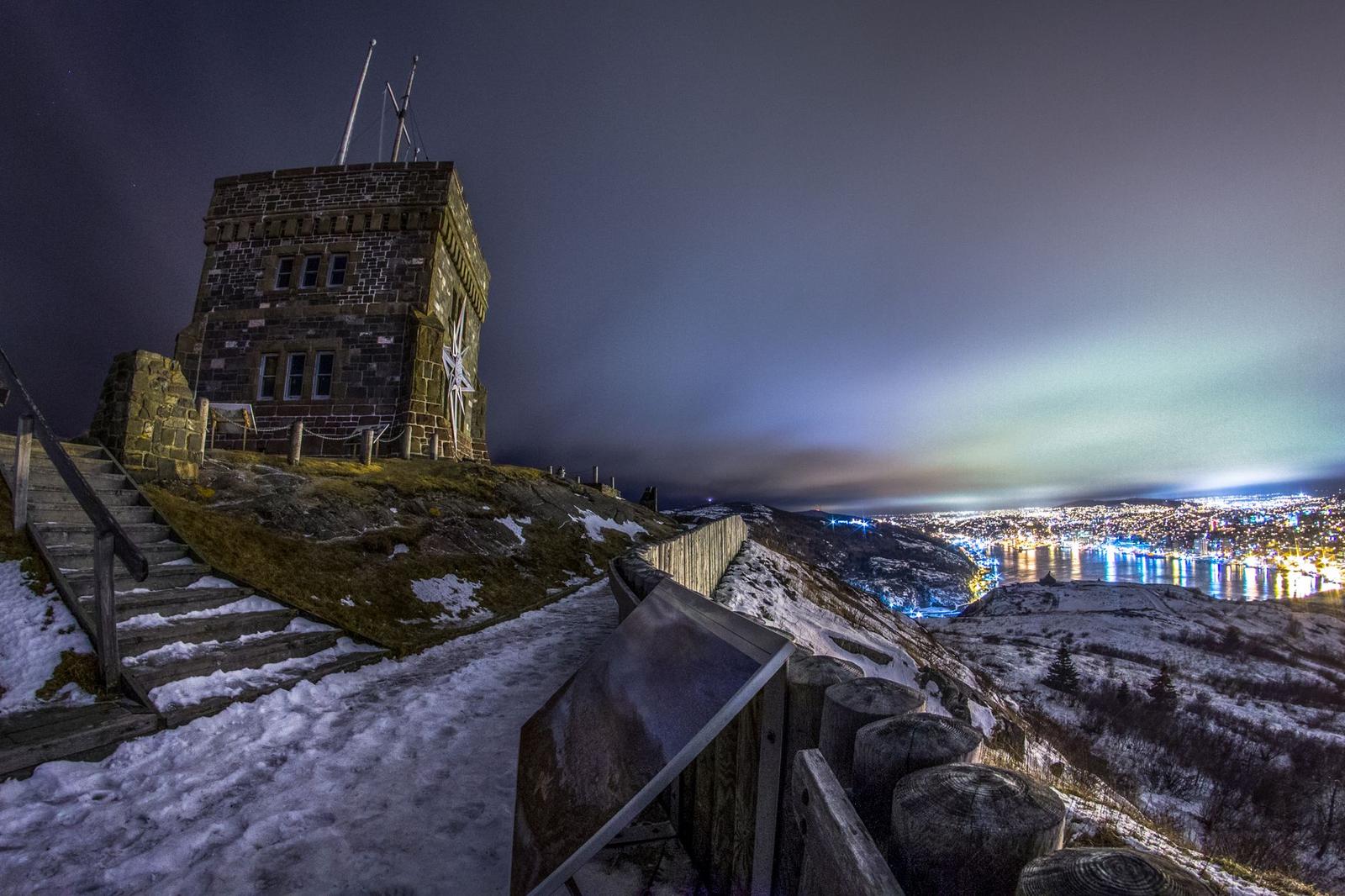 Cabot Tower exterior against Atlantic Ocean and stairs with snow on Signal Hill at dusk in Newfoundland and Labrador Canada