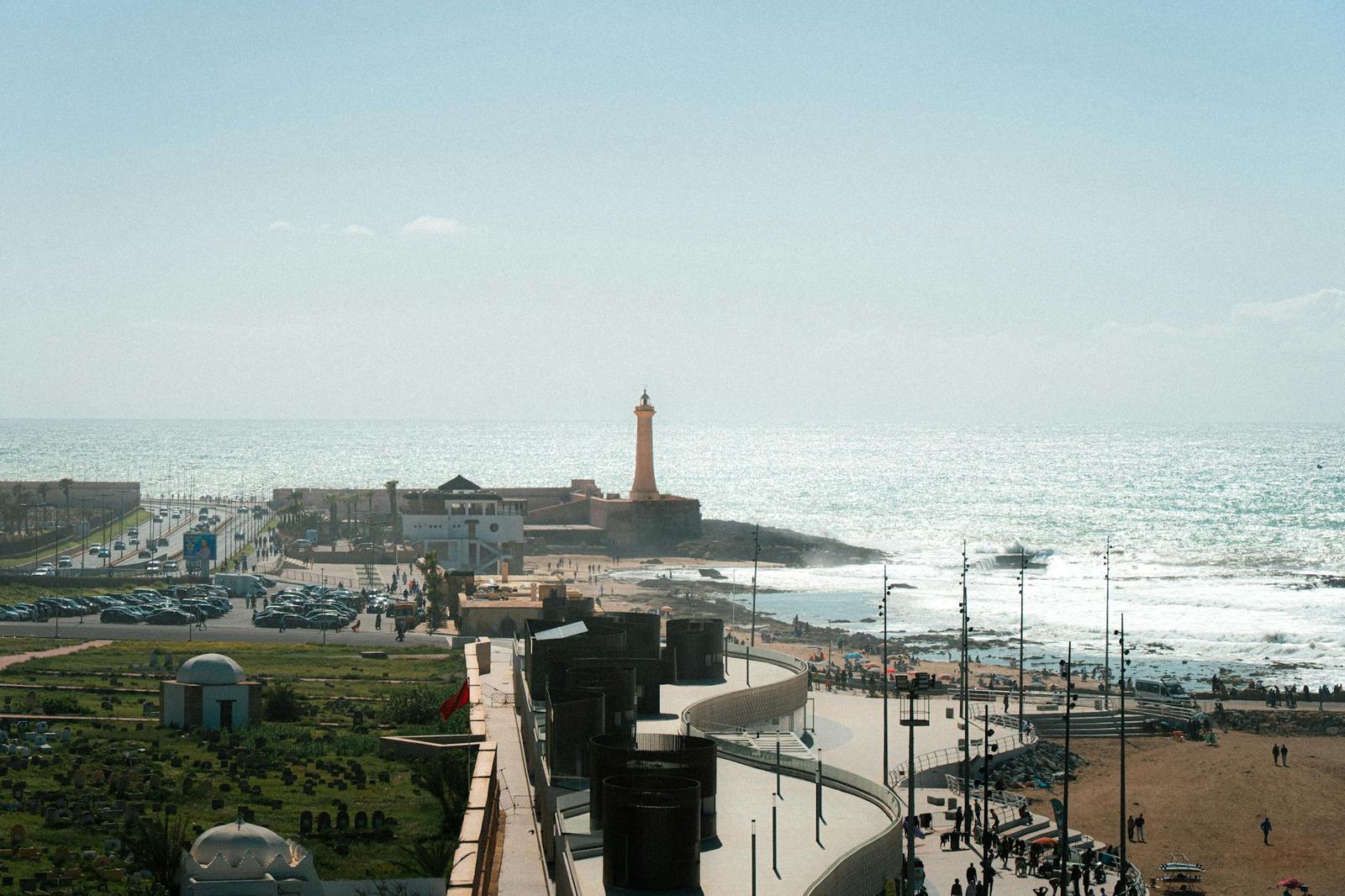 A coastal promenade with a tall lighthouse overlooking the ocean