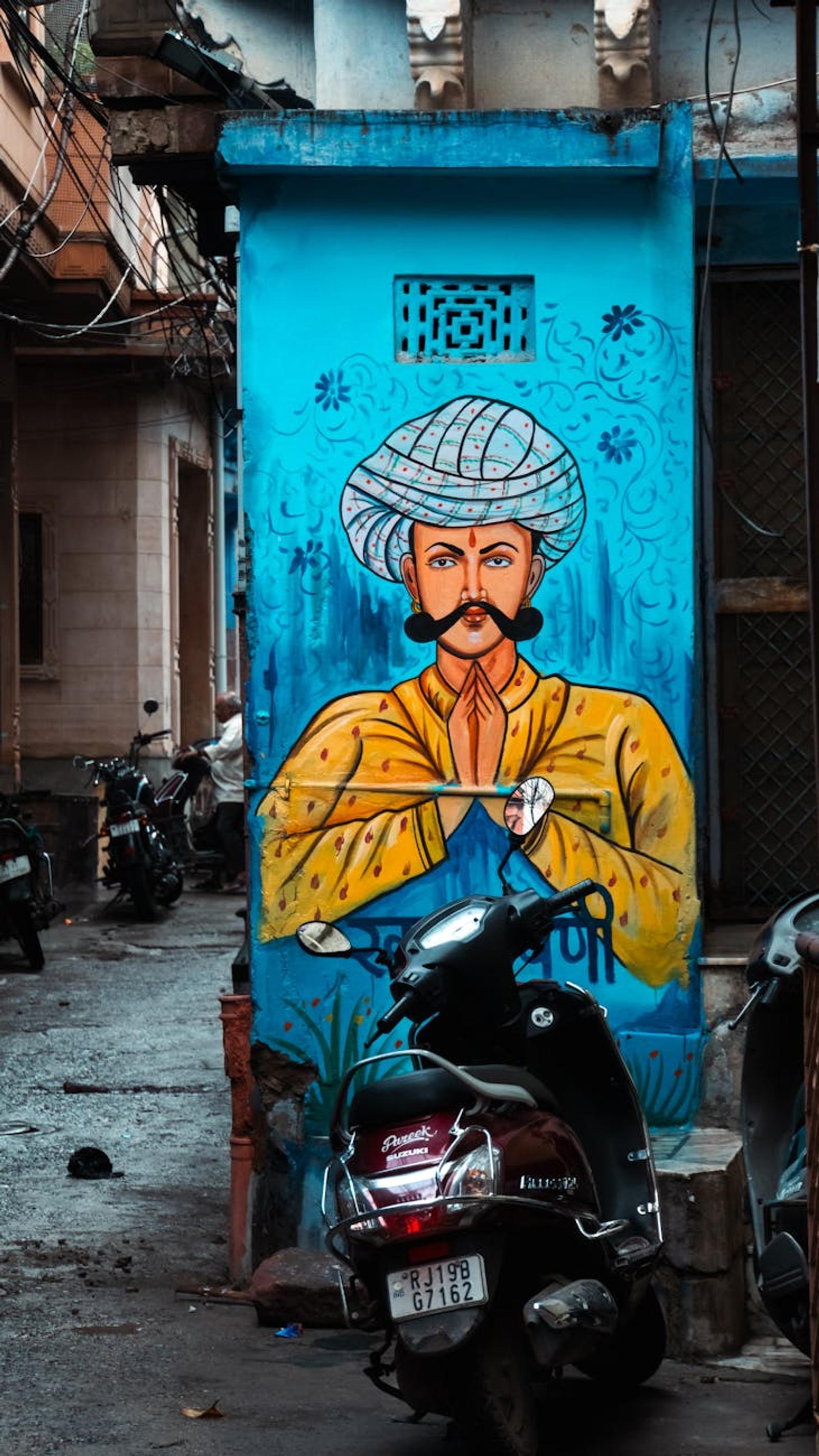 Colorful mural of a traditional figure in a bustling urban alley