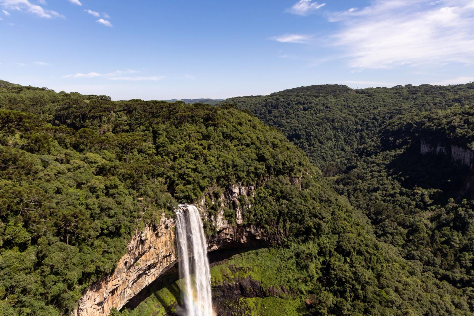 Stunning aerial view of Caracol Falls in Gramado, Brazil with lush green forest and clear sky
