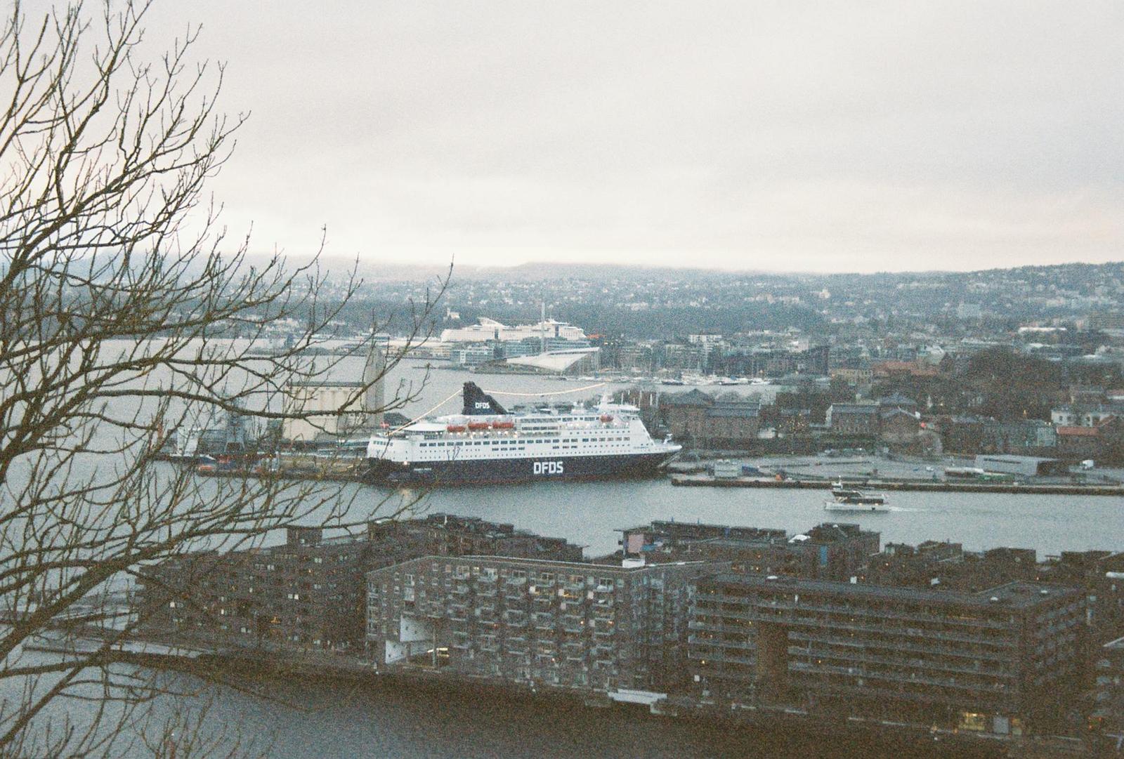 A large ferry docked at a harbour with apartment blocks lining the waterfront