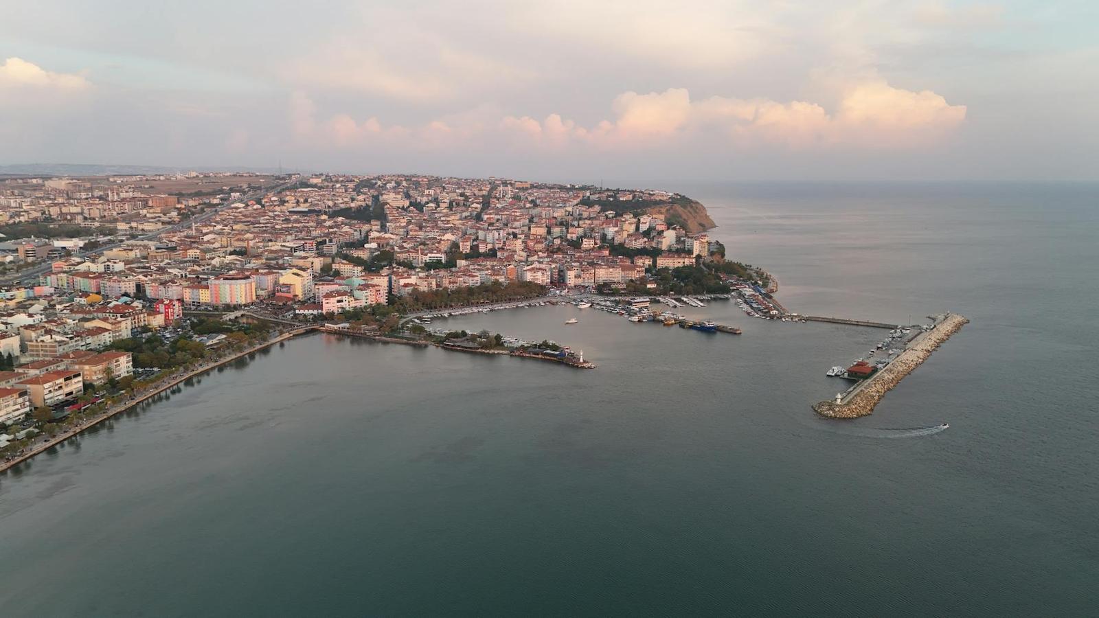 Aerial view of a coastal town with a harbour breakwater at dusk