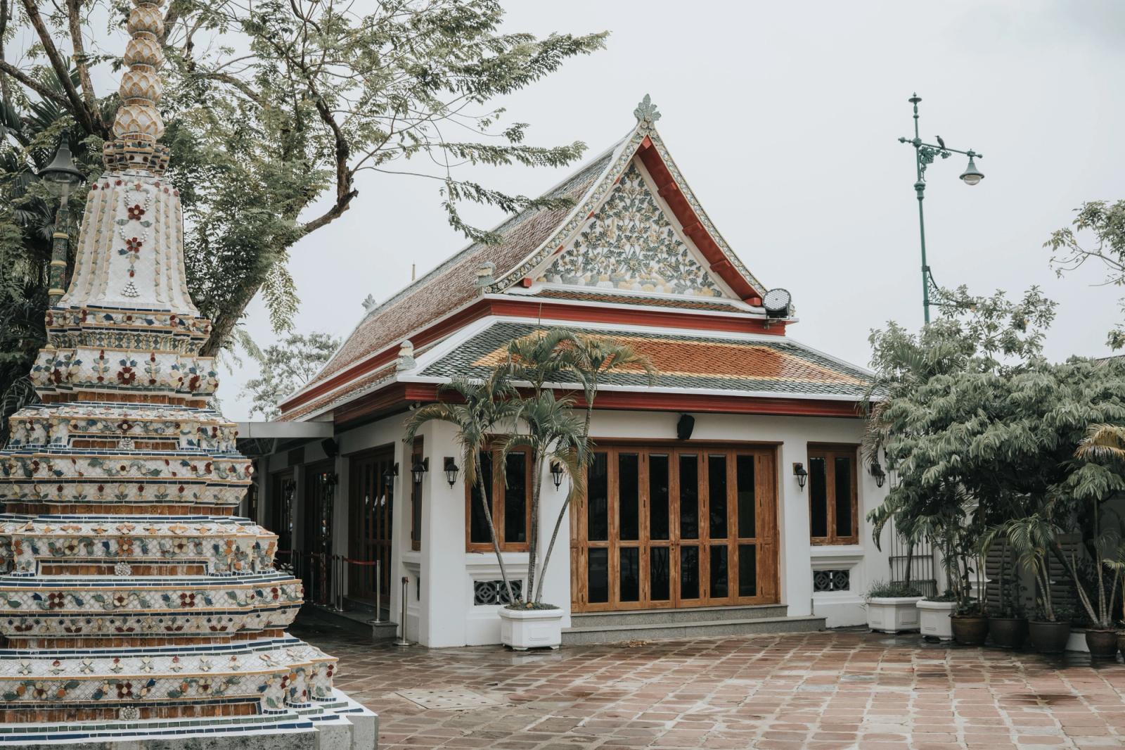 Explore the detailed architecture of Wat Pho Temple in Bangkok, Thailand, surrounded by lush greenery