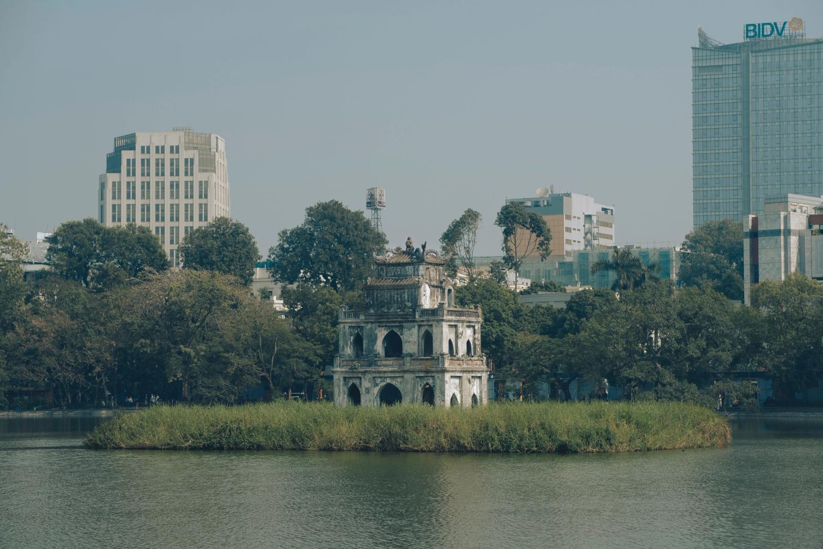 Scenic view of Turtle Tower in Hanoi's Hoan Kiem Lake surrounded by urban buildings