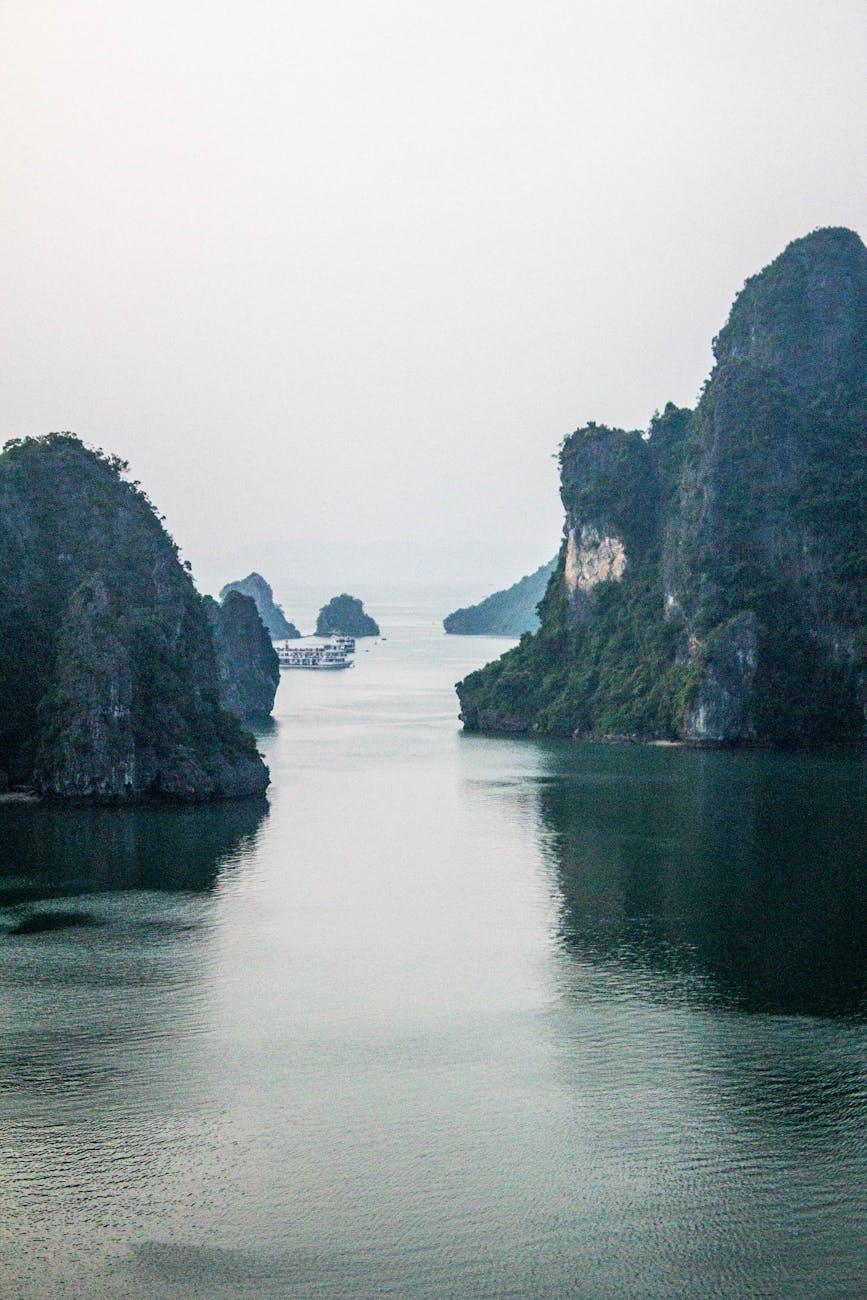 Serene landscape of karst formations in Halong Bay, Vietnam, with calm waters and overcast sky