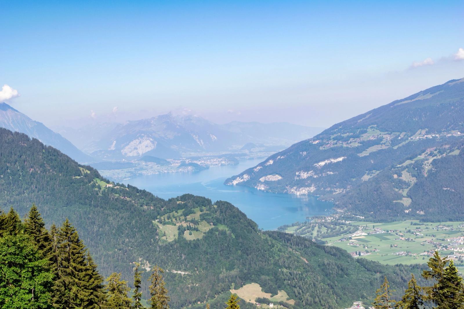 Aerial view of a hazy alpine lake framed by wooded ridgelines