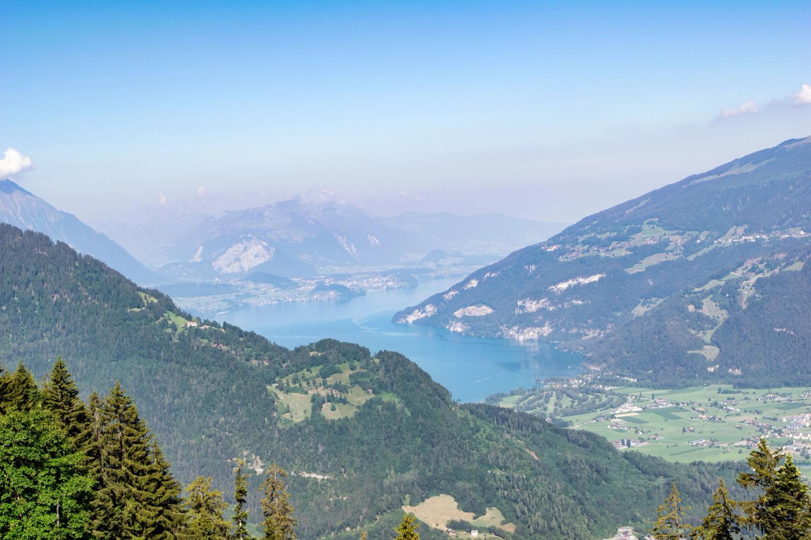 Aerial view of a hazy alpine lake framed by wooded ridgelines