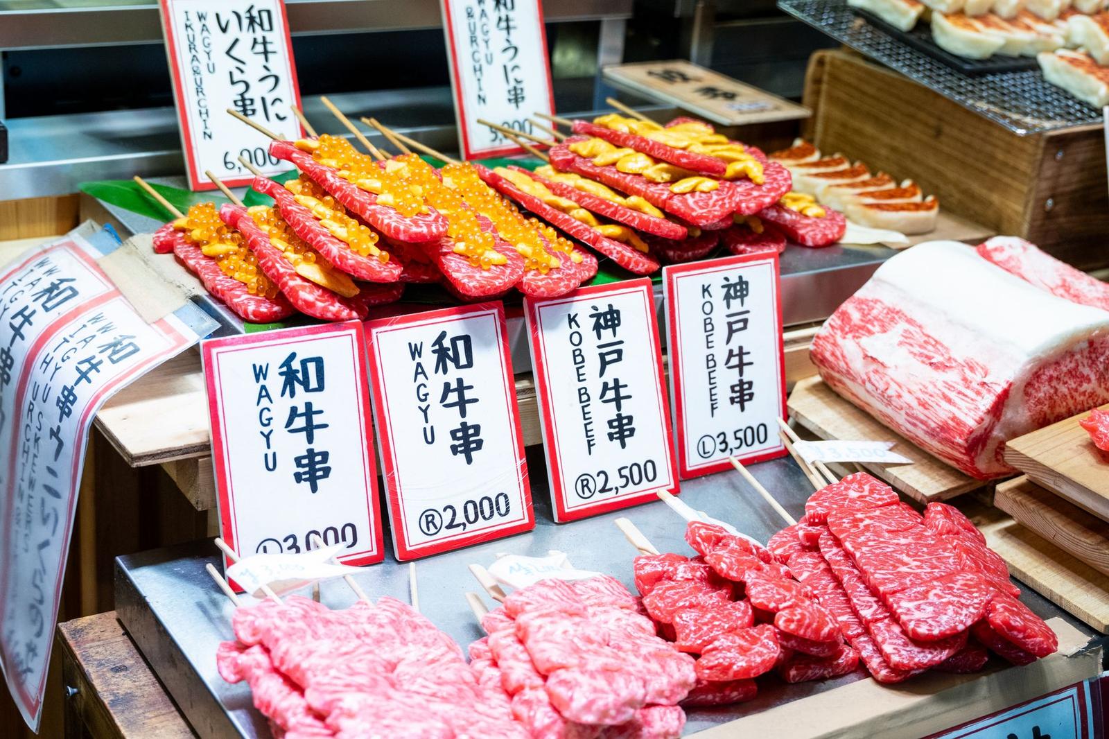 Skewered wagyu and Kobe beef displayed on a market stall with price tags