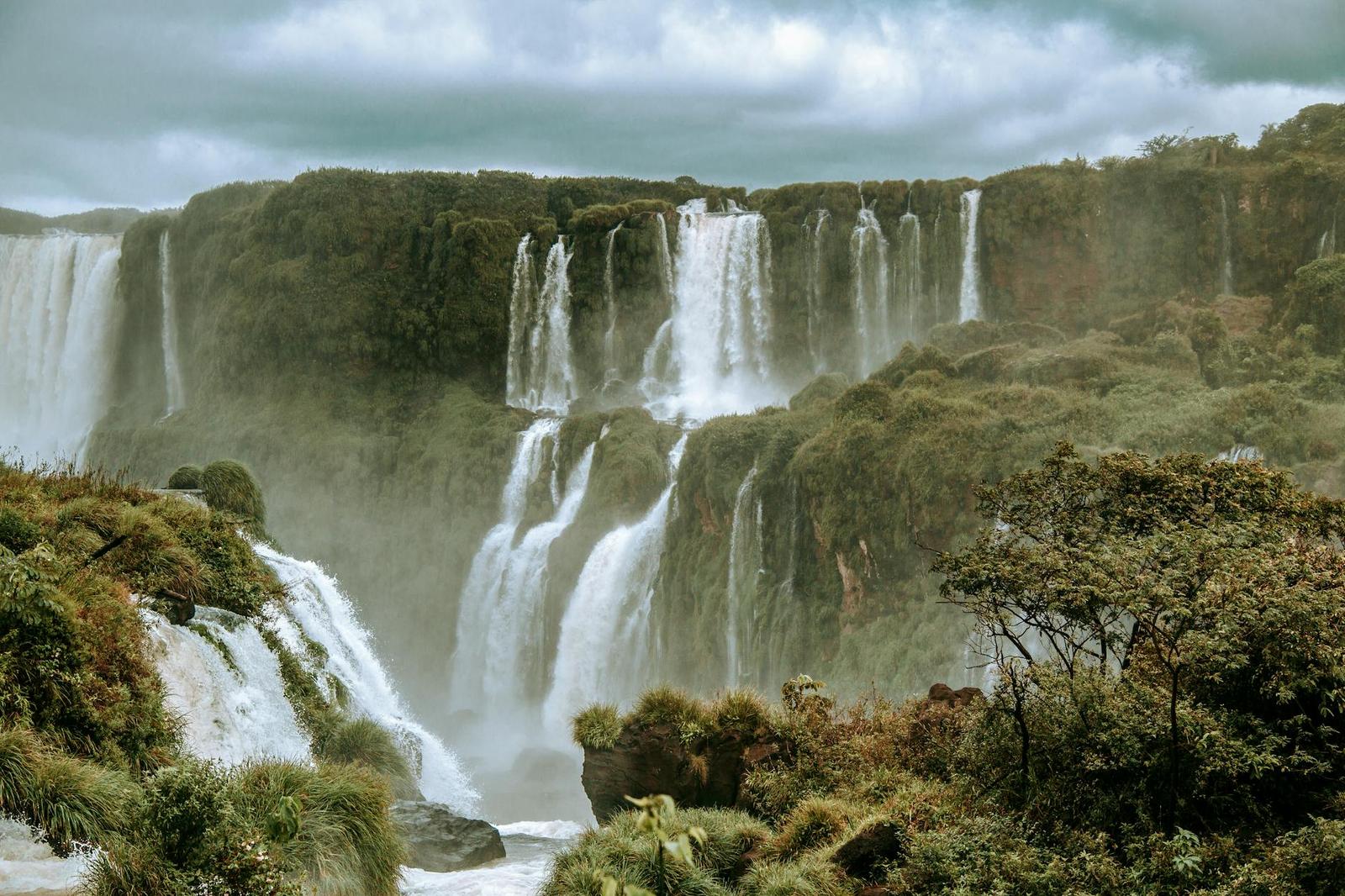 Wide horseshoe of waterfalls thundering into a river gorge