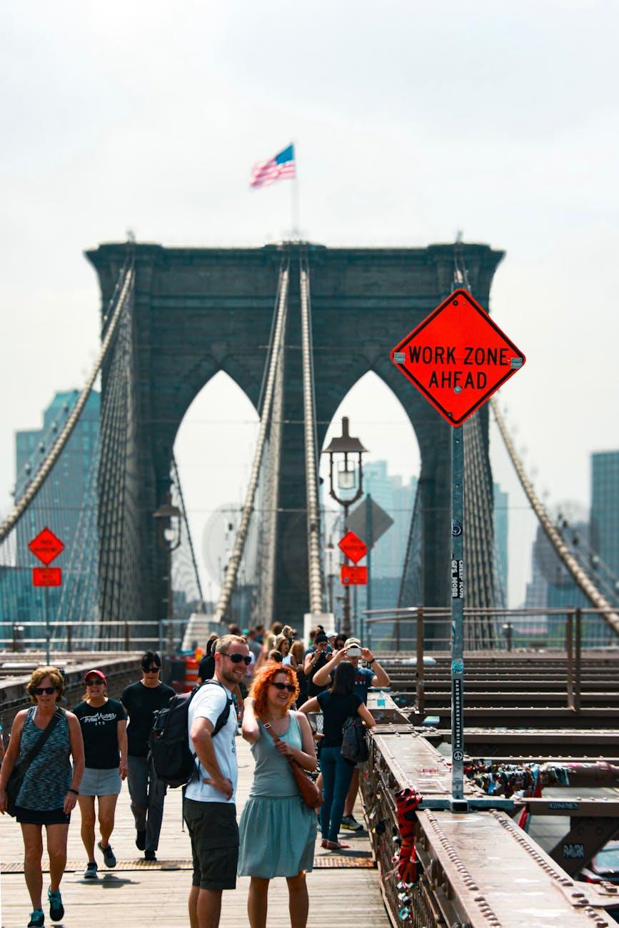 Couple posing on a pedestrian bridge walkway beneath stone towers