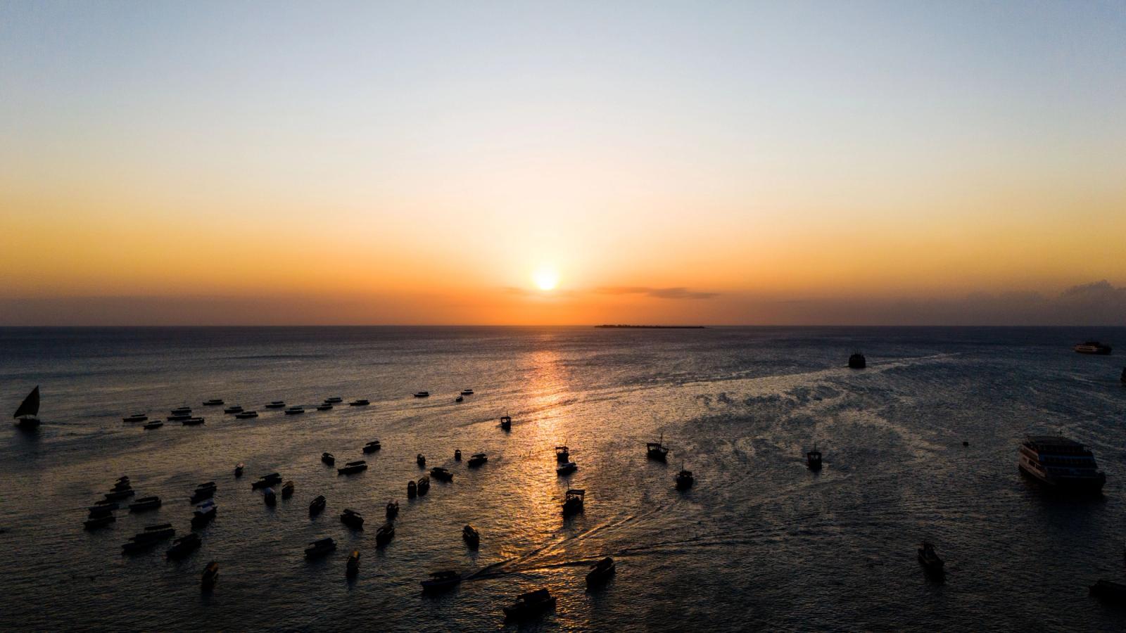 Serene sunset view with boats in the waters of Stone Town, Zanzibar