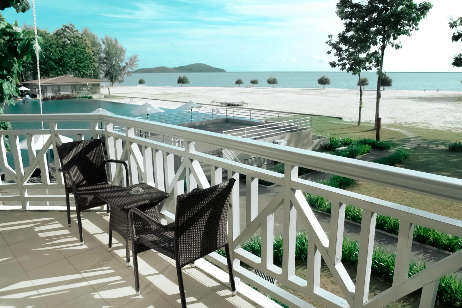 Elegant balcony setting with a stunning view of the ocean and pool, perfect for a serene escape