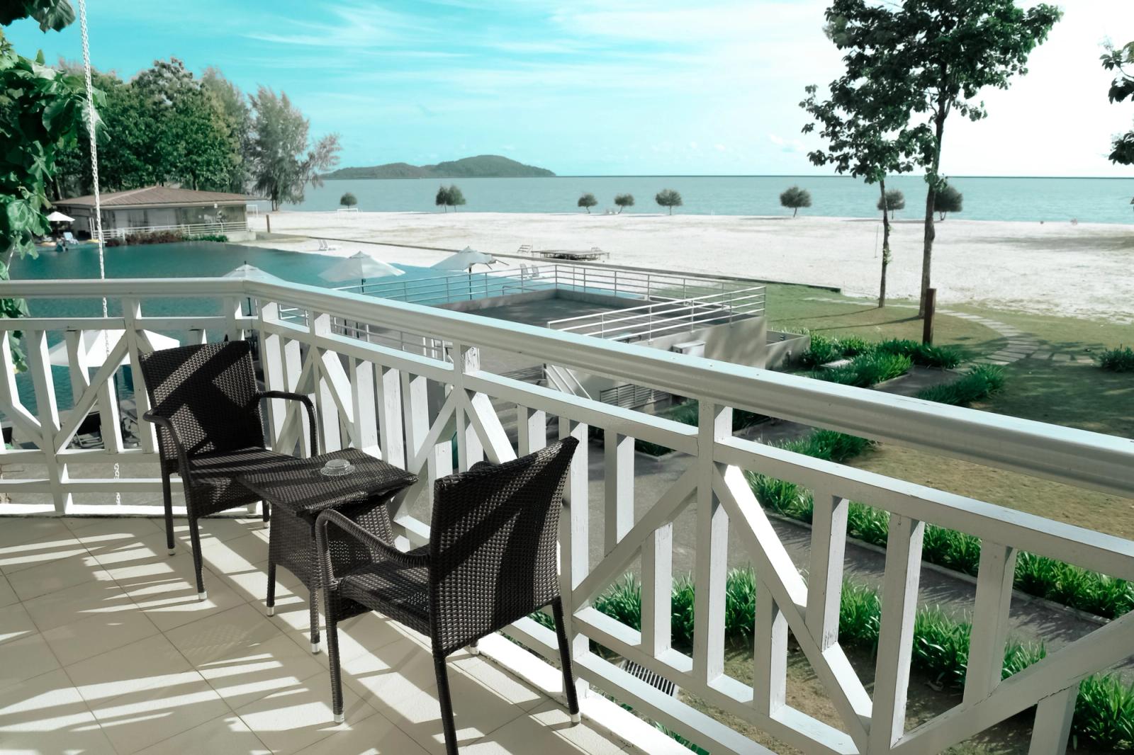 Elegant balcony setting with a stunning view of the ocean and pool, perfect for a serene escape