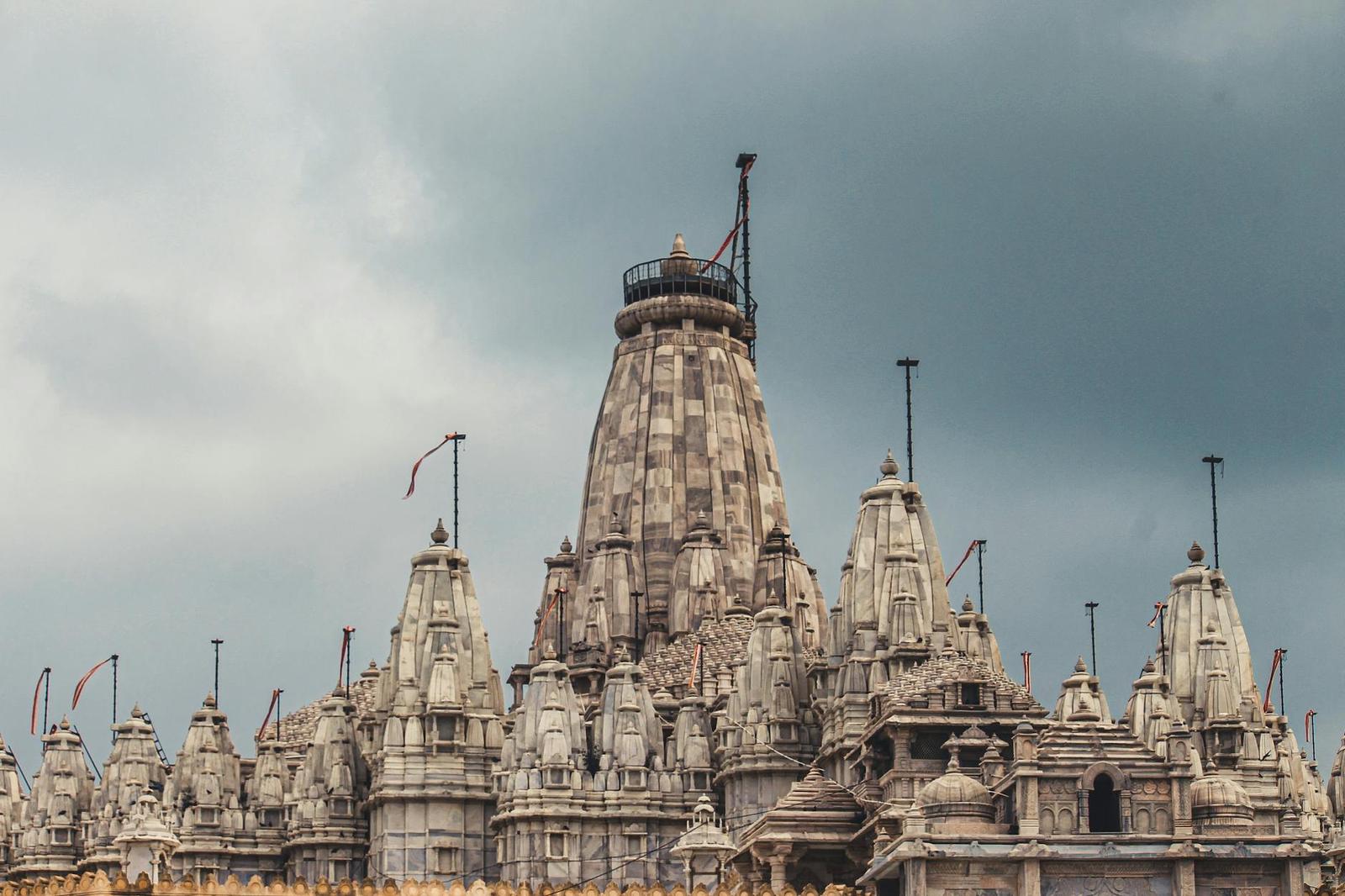 Ornate carved temple spires rising beneath a stormy grey sky