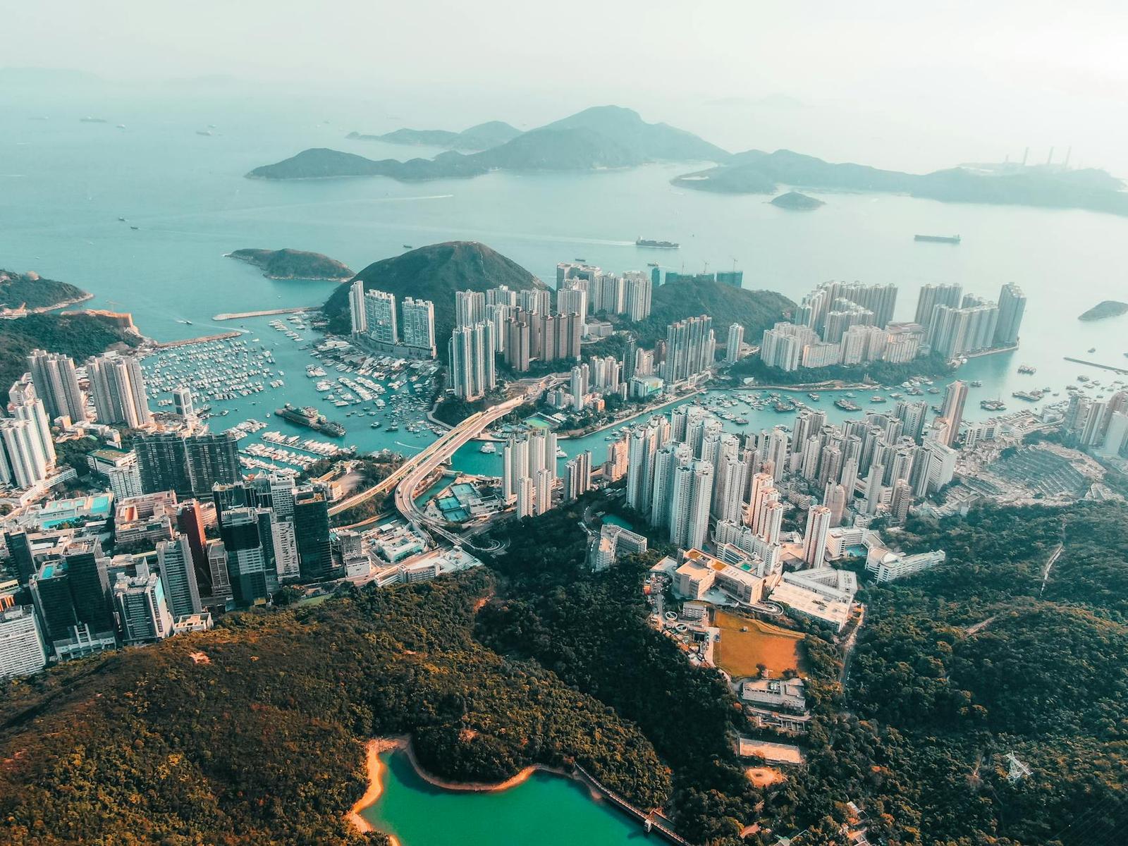 An aerial view of a harbour city with skyscrapers and green islands