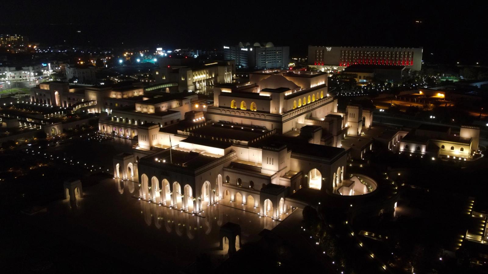Aerial view of the illuminated Royal Opera House in Muscat at night