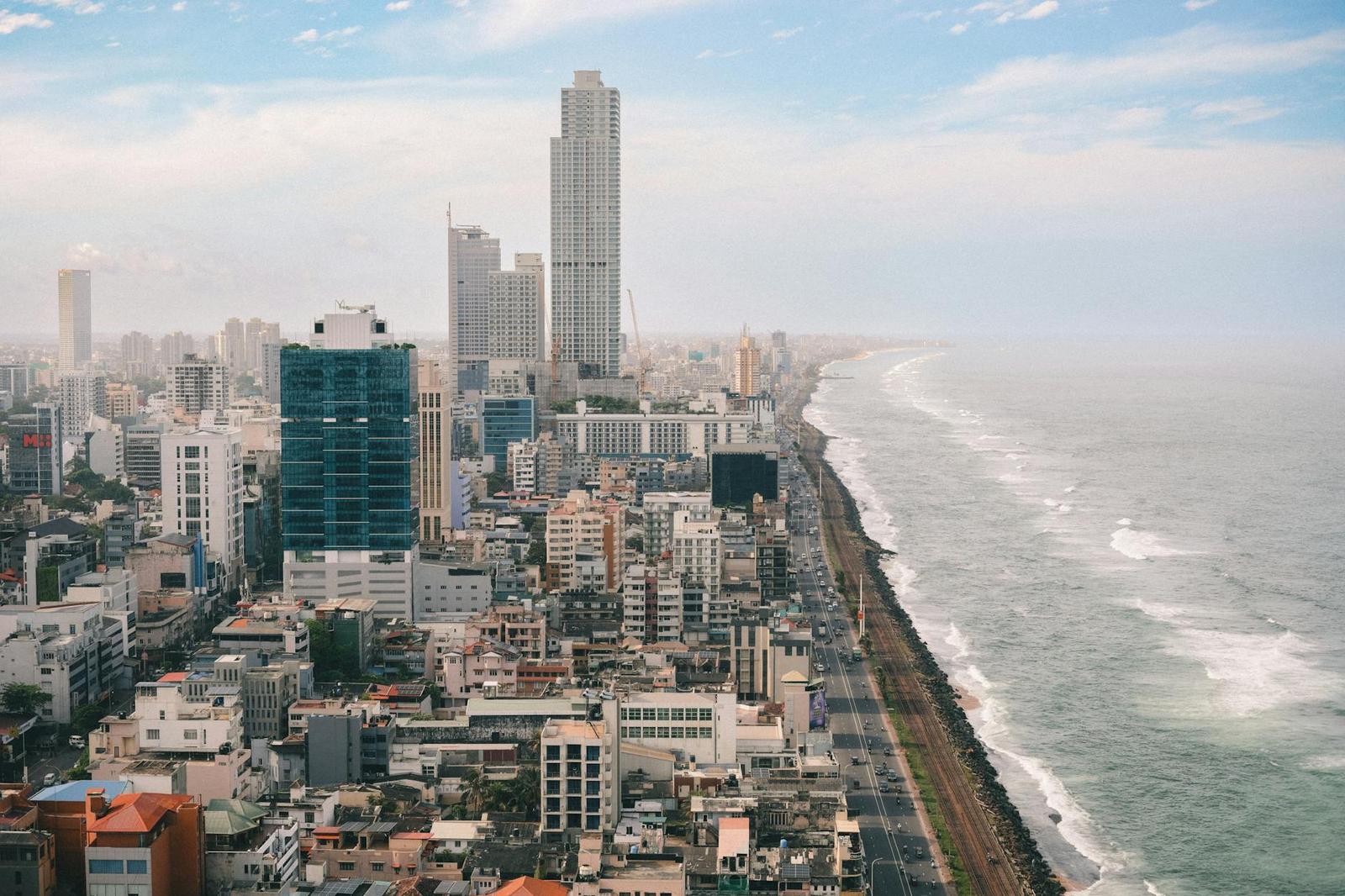 Coastal city skyline beside a long shoreline with breaking waves