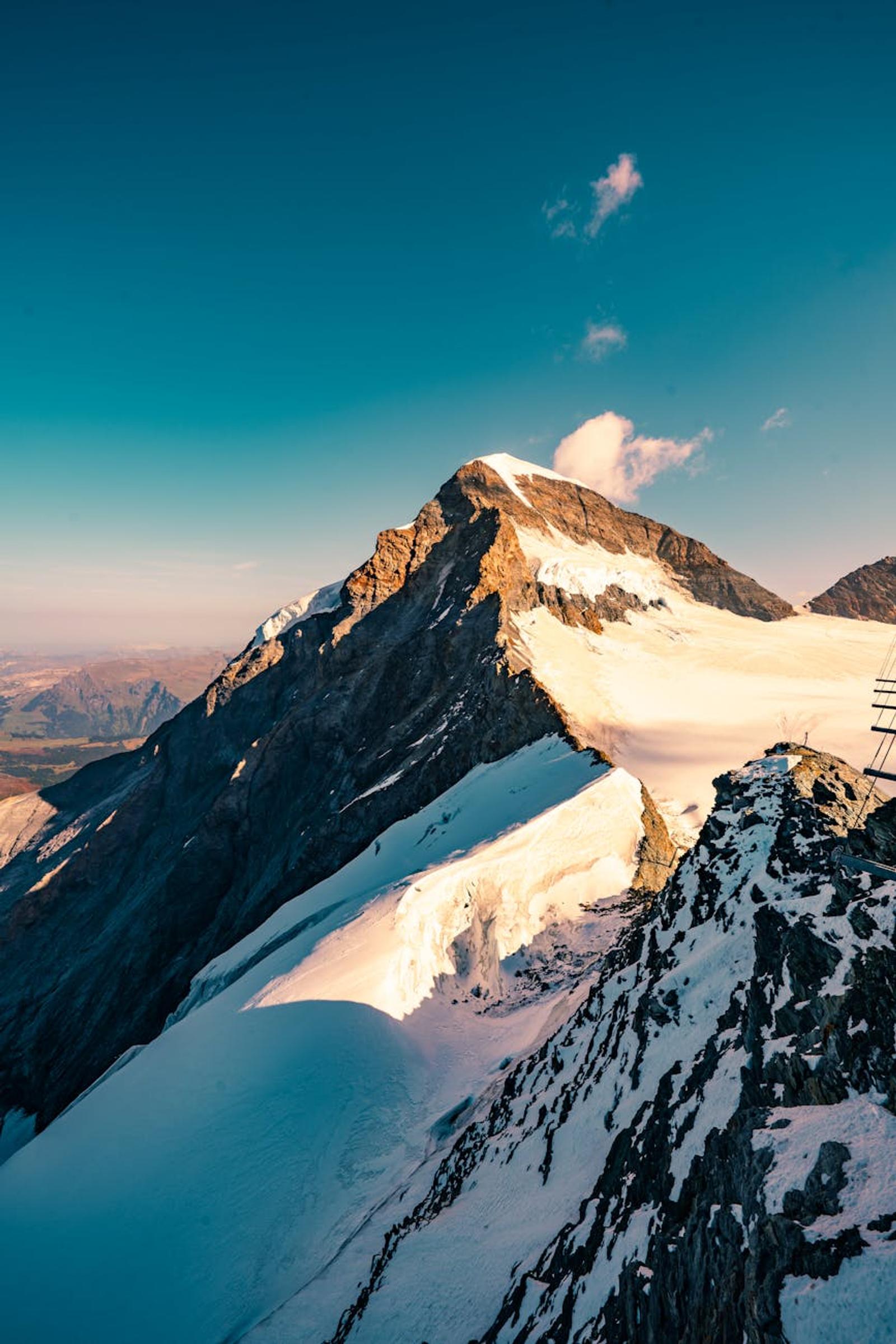 Golden light on a snow-streaked summit ridge at sunset