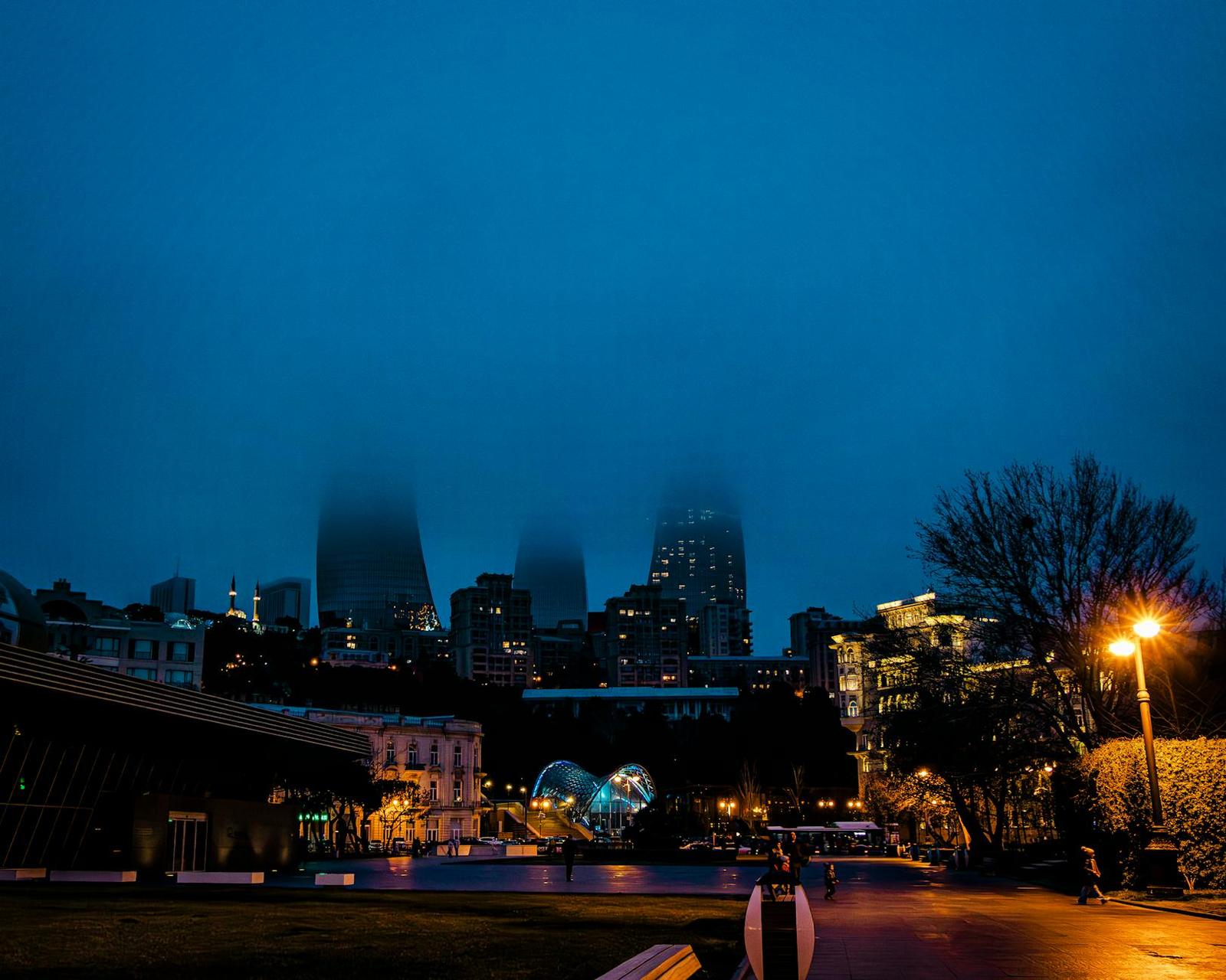 Atmospheric night view of Baku's skyline with mist over modern architecture, Azerbaijan