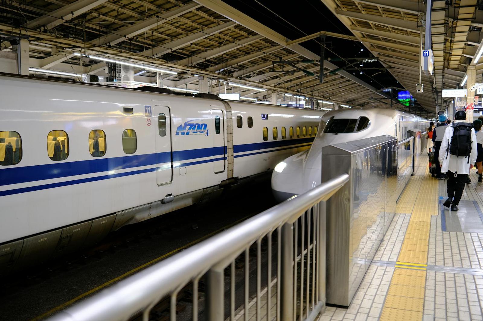 Shinkansen bullet train at a busy Tokyo station platform with passengers boarding