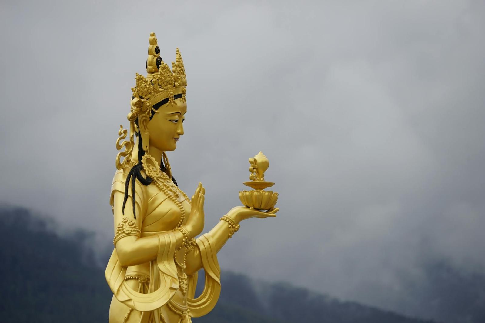 Majestic golden statue of a Buddhist deity in Thimphu, Bhutan against a cloudy sky