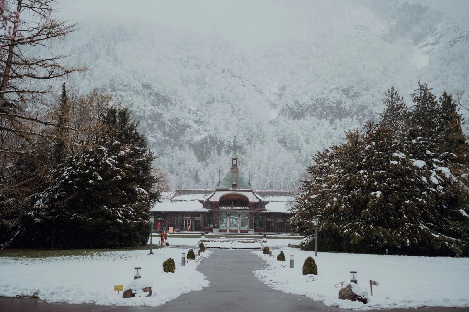 A serene winter scene featuring a historic building surrounded by snow-covered trees in Switzerland