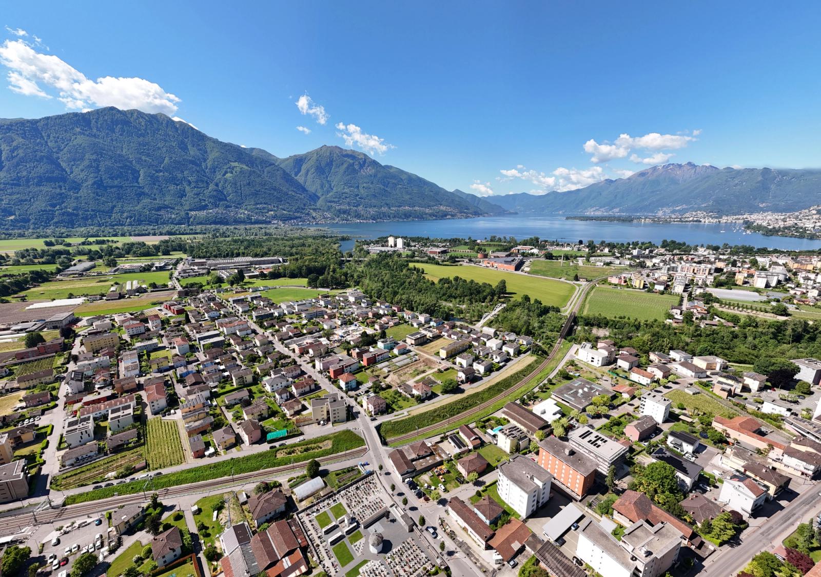 Aerial photograph showcasing Locarno, Lake Maggiore, and surrounding mountains on a clear summer day